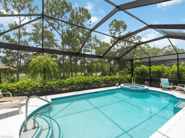 View of pool with an in ground hot tub and a lanai