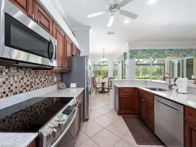Kitchen featuring appliances with stainless steel finishes, crown molding, and sink