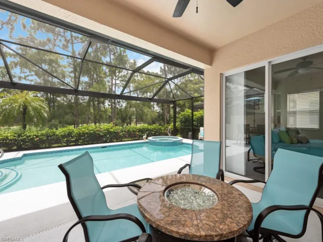 View of swimming pool featuring a patio, ceiling fan, and a lanai