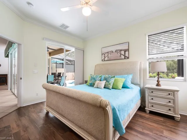 Bedroom with dark wood-type flooring, crown molding, access to exterior, and ceiling fan