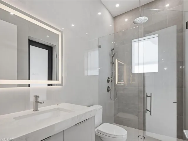 Full bath with a shower stall, vanity, and recessed lighting