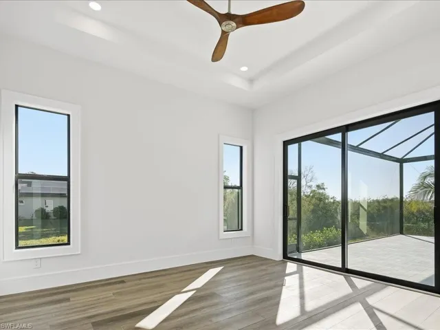 Spare room featuring light wood-type flooring, a ceiling fan, healthy amount of natural light, a sunroom, and recessed lighting