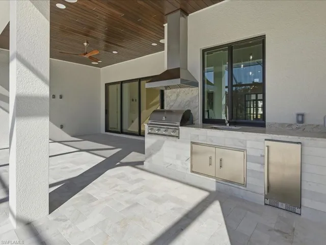 View of patio with a ceiling fan and an outdoor kitchen