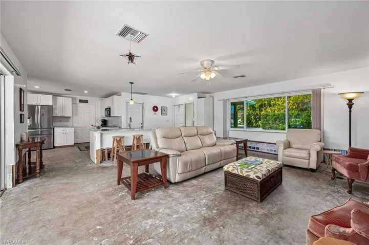Living room featuring recessed lighting, and an open floor plan wih the kitchen and breakfast bar.