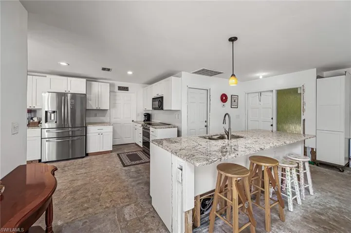 Kitchen featuring appliances with stainless steel finishes, a sink, and plenty of white cabinetry.