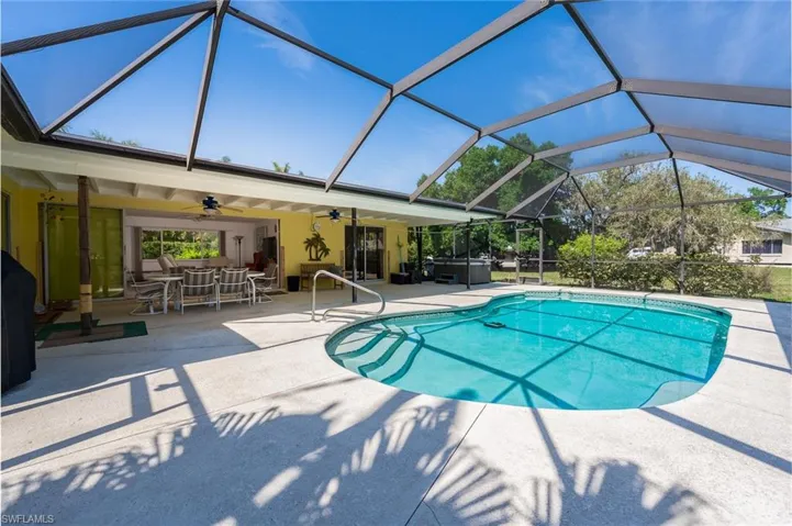 Pool featuring outdoor dining area, a patio, a ceiling fan, pocketed doors and an above ground spa.
