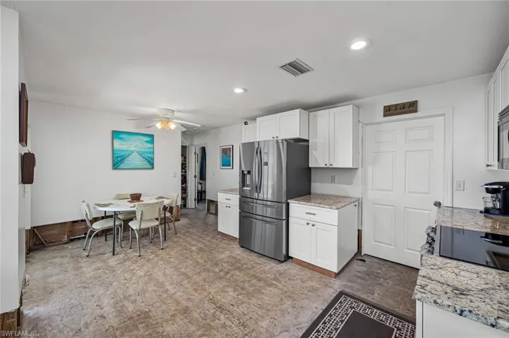 Kitchen featuring visible vents, stainless steel fridge with ice dispenser, and breakfast or dining area.