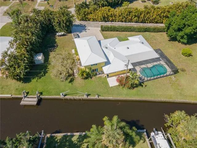 Bird's eye view of the very private driveway and large parking area with a clear view of the direct access canal leading to the river.