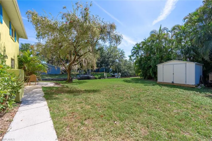 View of side yard with an outdoor paver patio and a storage shed,  Home has 200 ft of waterfront property and you can see the boat lift in this picture.