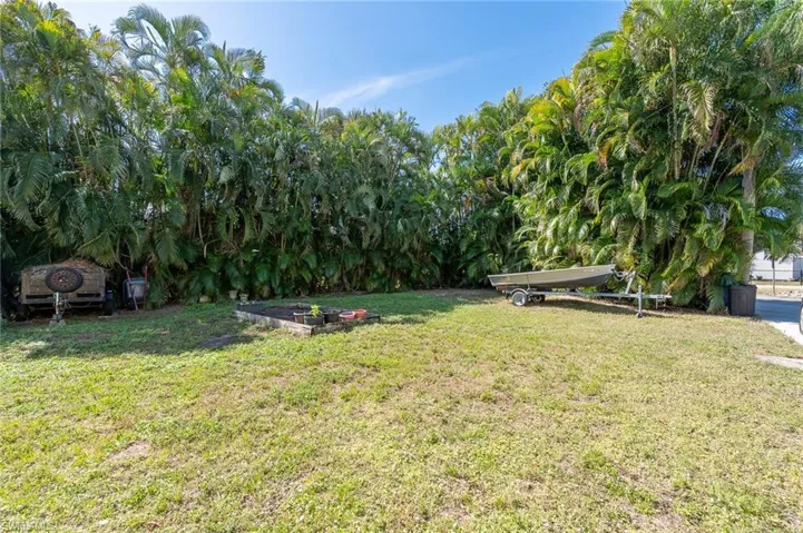 View of very private yard featuring a vegetable garden and lots of privacy palms.  Also has 30 amp service for an RV parking.