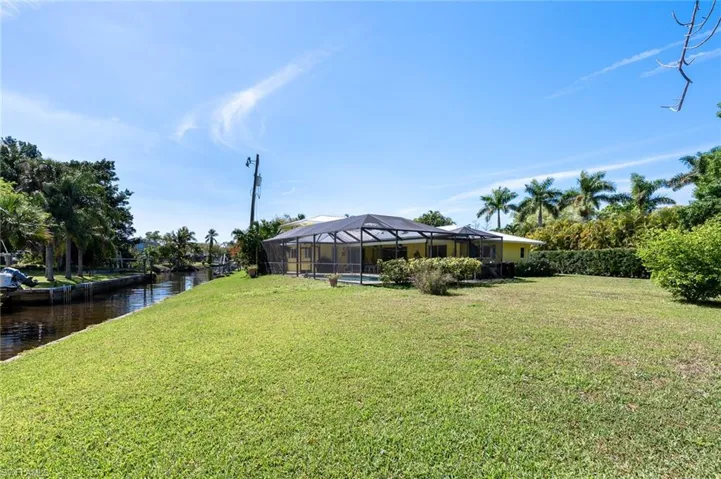 View of yard featuring a large mansard caged pool and a water view