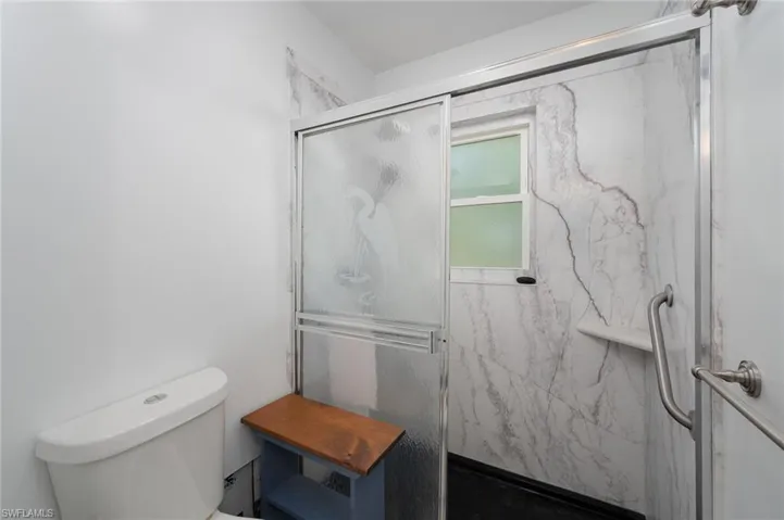 Full bathroom featuring toilet and a marble finished shower