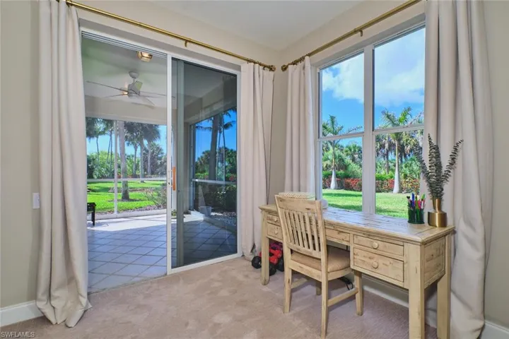 Office space with a ceiling fan, light colored carpet, and plenty of natural light