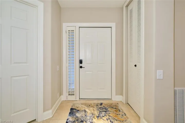 Foyer with baseboards and light tile patterned floors