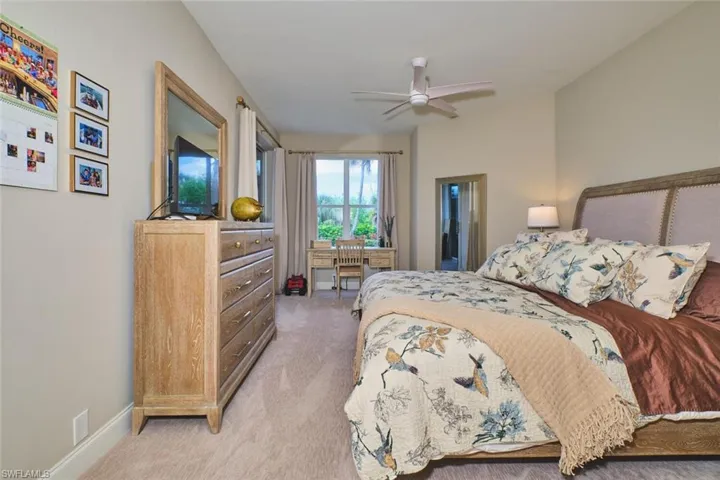 Bedroom with ceiling fan and light carpet