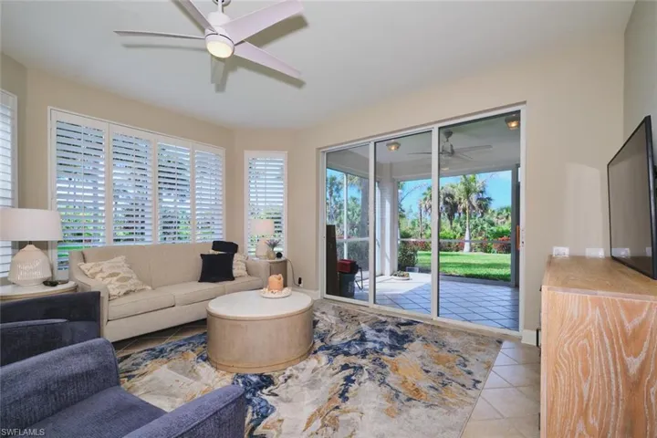 Living room featuring ceiling fan, light tile patterned floors, and healthy amount of natural light
