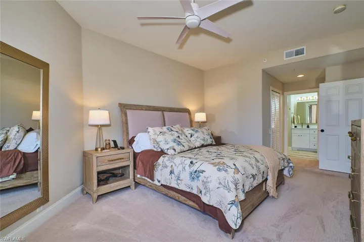 Bedroom with carpet, ensuite bathroom, and ceiling fan