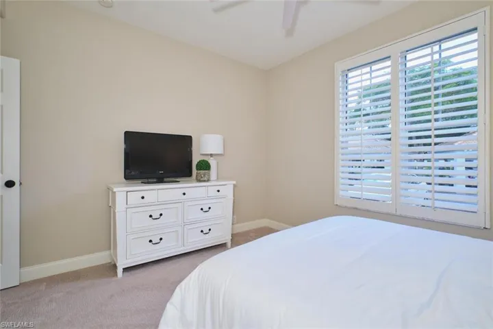 Bedroom featuring light colored carpet and ceiling fan