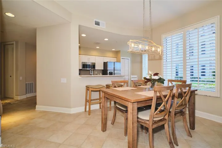 Dining area with recessed lighting and light tile patterned floors
