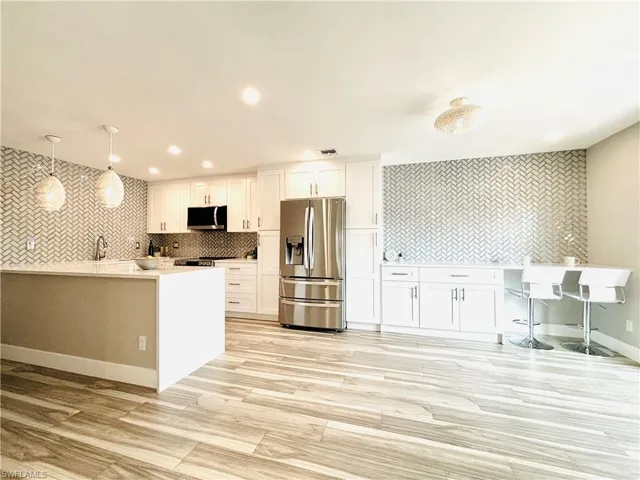 Living room featuring light wood-type tile flooring and recessed lighting