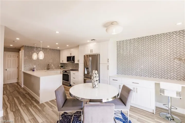 Dining area adjacent kitchen and breakfast bar features stylish  full wall back-splash
