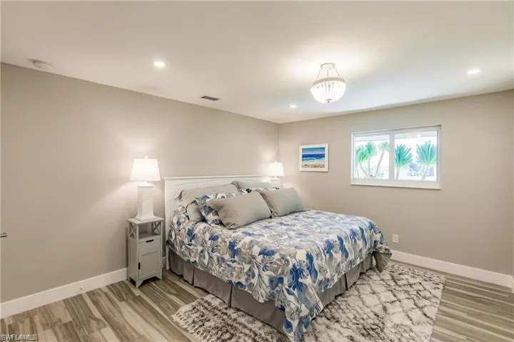 Spacious primary bedroom, light wood-style tile floors, and recessed lighting