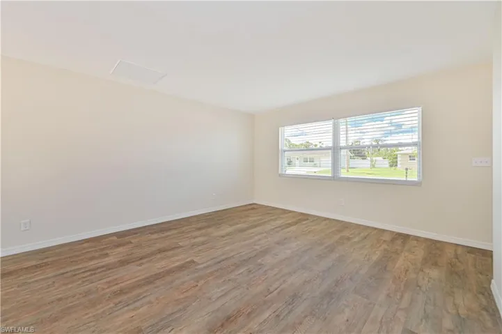 Unfurnished room featuring wood finished floors and baseboards