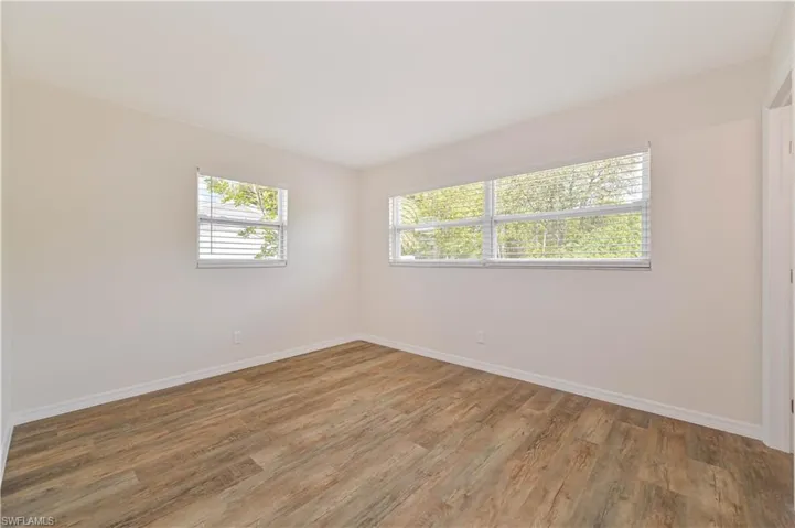 Spare room featuring wood finished floors and baseboards