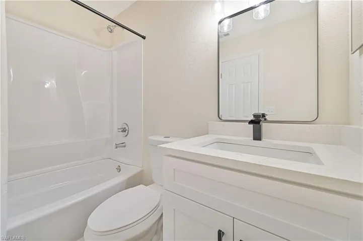 Full bathroom with toilet, vanity, and bathing tub / shower combination