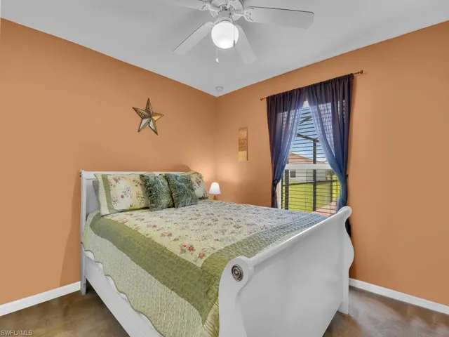 Bedroom featuring ceiling fan and dark carpet