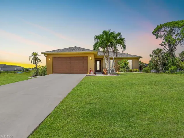 Ranch-style house with a yard and a garage