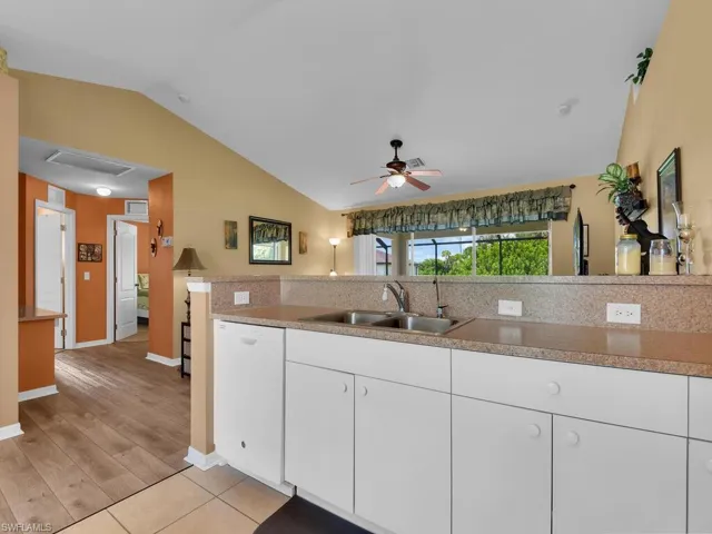 Kitchen with white dishwasher, light hardwood / wood-style flooring, white cabinets, sink, and ceiling fan