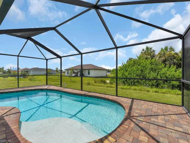 View of pool with a patio, a lanai, and a yard