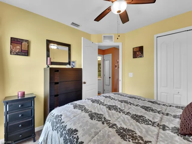 Carpeted bedroom featuring ceiling fan and a closet