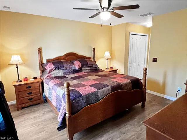 Bedroom with wood-type flooring, a closet, and ceiling fan