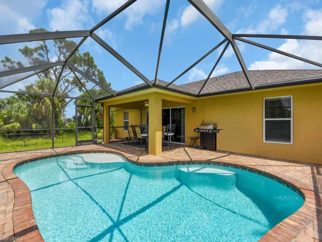 View of pool with a lanai and a patio area