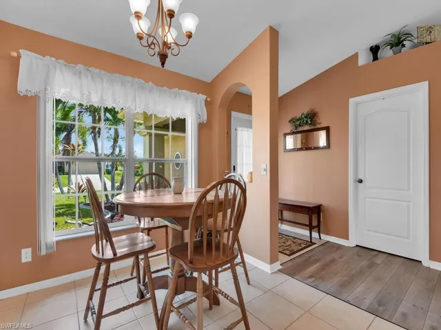 Dining area featuring a notable chandelier, light tile floors, and lofted ceiling