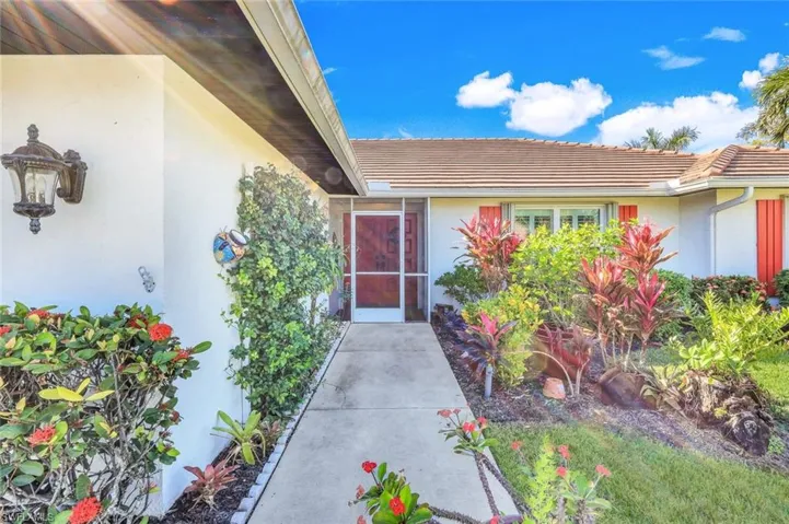 Entryway is adorned by lush landscaping.