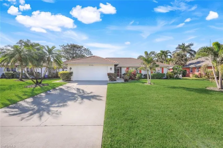 Home features a long driveway and a two car garage.