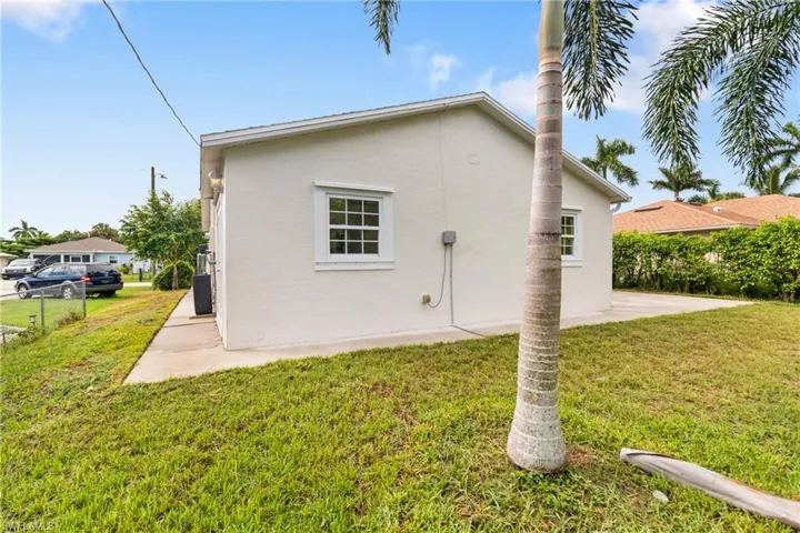 Back of property featuring stucco siding and a lawn