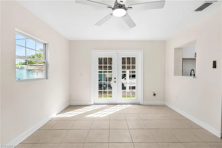 Spare room with light tile patterned floors, french doors, and ceiling fan