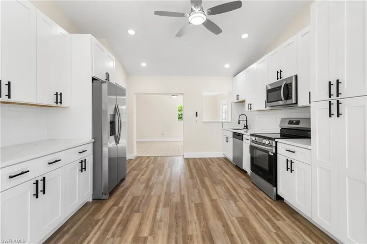 Kitchen featuring decorative backsplash, a ceiling fan, appliances with stainless steel finishes, recessed lighting, and light wood-type flooring