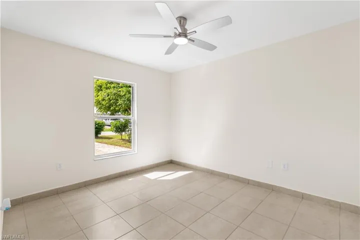 Spare room with light tile patterned flooring and ceiling fan