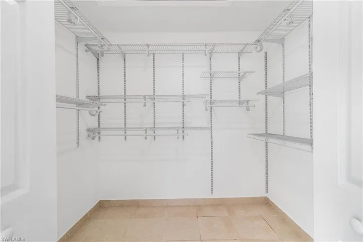 Spacious closet with light tile patterned floors