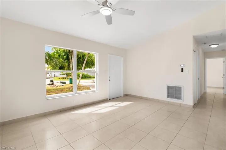 Unfurnished room featuring light tile patterned floors and ceiling fan