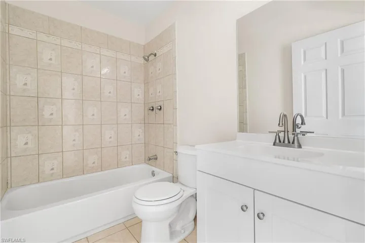 Full bathroom with tile patterned floors, vanity, and bathing tub / shower combination