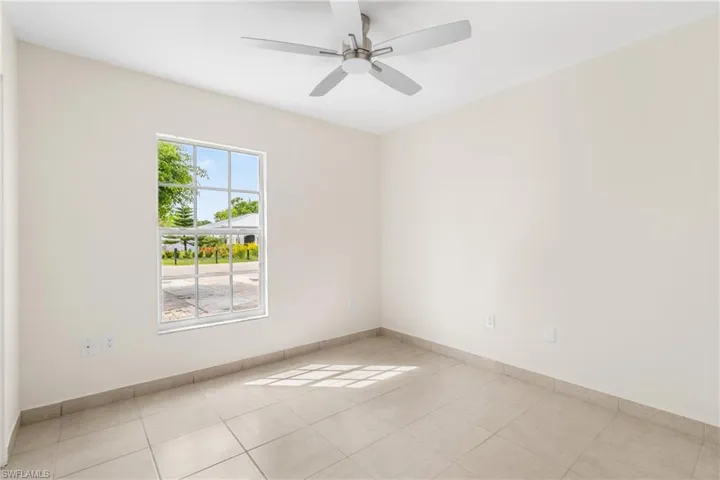 Empty room with tile patterned floors and ceiling fan