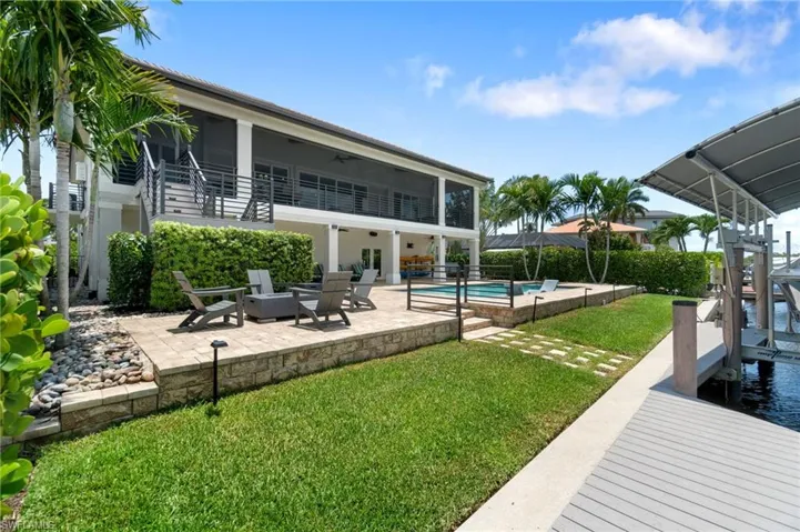Rear of home Featuring pool, spa, tons of outdoor space, fire pit, water frontage, dock and multiple boat and jet ski lifts.