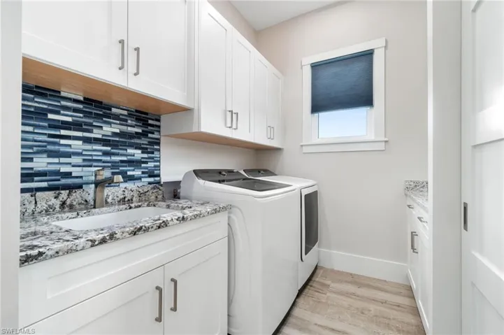 Laundry Room with sink, cabinets and custom backsplash.