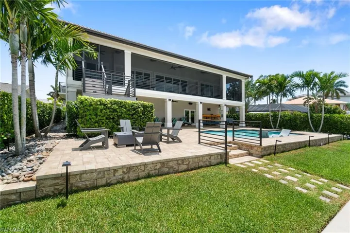 View of pool featuring a lanai, gas fire pit and a yard